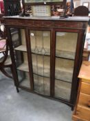 A 1930s darkwood display cabinet with leaded glass door and string inlay