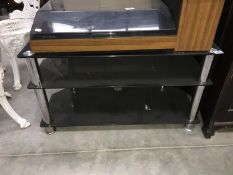 A dark glass 3 tiered TV stand