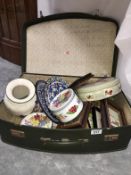 A suitcase and contents including tins,