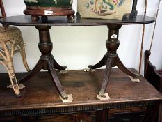 A twin pedestal coffee table with brass claw feet