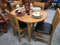 A light wood exteding dining table and 4 leather seated chairs