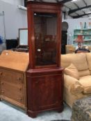 A dark wood stained kitchen corner cabinet