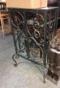 A wrought iron free standing locable wine rack