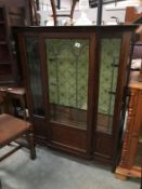 An inlaid mahogany display cabinet with leaded glass doors