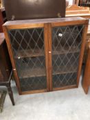 An oak book case with leaded glass doors