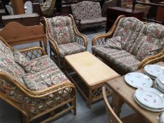 A 3 piece cane conservatory suite with table