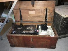 A wooden chest containing old electrical items