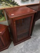 A dark wood stained glass fronted music cabinet