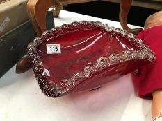 A large heavy cranberry coloured glass bowl