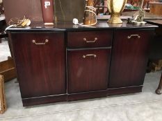 A small dark wood stained sideboard