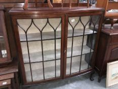 A 1930s mahogany astragal glazed cabinet with claw and ball feet