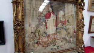 A large 19th century tapestry of a huntsman presenting captured game to a priest in ornate gilt