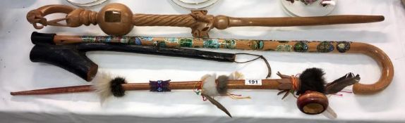 A carved walking stick, a walking stick with badges & 2 other items