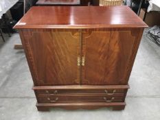 A dark wood polished TV cabinet