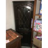 A dark oak stained corner cupboard