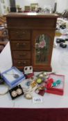 A wooden jewellery cabinet with costume jewellery