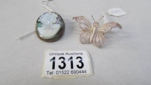 A shell cameo brooch and a silver filigree butterfly brooch