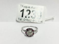 An 18ct gold ring cut diamond 30pts surrounded by rubies,