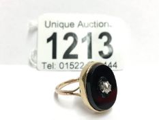 An 18ct yellow gold onyx oval ring with cartal diamond,