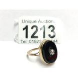 An 18ct yellow gold onyx oval ring with cartal diamond,