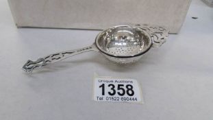 A silver tea strainer marked S Ltd,