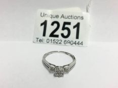 An 18ct white gold floral diamond ring with diamond shanks,