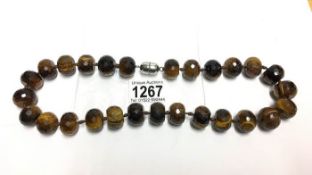 A necklace of tiger's eye stone beads with silver magnetic clasp