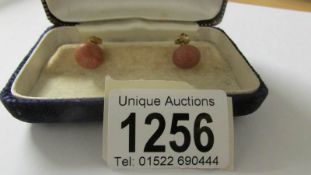 A pair of coral ear studs in 9ct gold