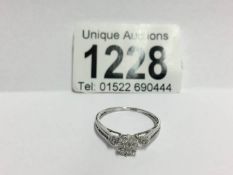 An 18ct white gold floral diamond ring with diamond shanks,