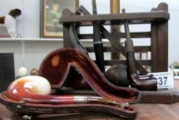 4 pipes and a pipe rack including silver mounted inscribed M Peterson