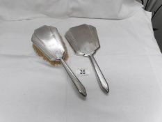 A silver backed hand mirror and hair brush