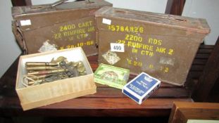 A collection of military memorabilia including ammo tins, buttons, identification,