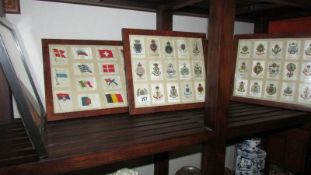 4 framed and glazed silks of regimental badges and 2 of flags