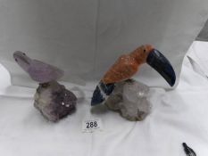 An amethyst parrot and a carved stone toucan