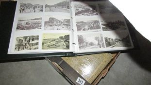 A box of albums containing post cards and 2 atlases