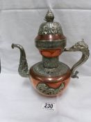 An eastern antique copper and white metal coffee pot decorated in relief with dragons