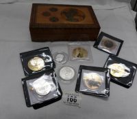 A quantity of commemorative coins including £5 in a wooden box