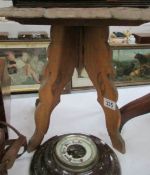 A carved wood table on tripod base