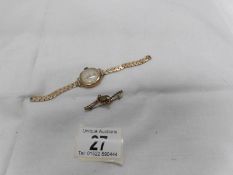 A 9ct gold brooch and an Avia 9ct gold ladies wrist watch