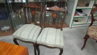 A pair of Edwardian mahogany inlaid chairs