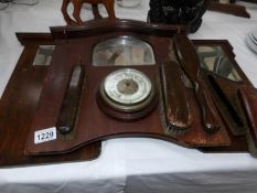 A barometer on a brush rack and one other brush rack