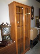 A modern teak glazed book case