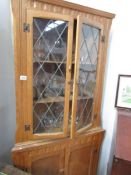 An oak astragal glazed corner cabinet
