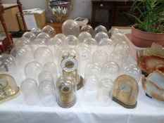 A large quantity of glass and plastic anniversary clock domes