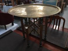 A folding brass topped table
