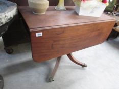 A drop leaf table with claw feet