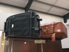 A suitcase on wheels and a brown suitcase