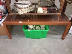 A teak coffee table with glass top