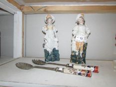 A pair of figures and a pair of salad servers