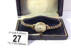 A Marvin ladies wrist watch with twisted gold strap, all gold cased, in working order, approx. 19.